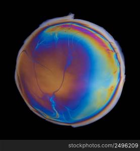 Vivid multicolored circle created by iridescent oil spill  film isolated on black background