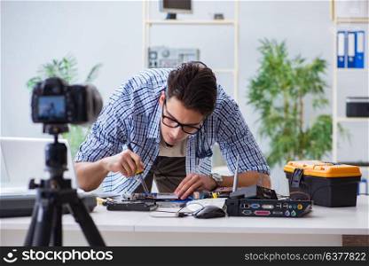 Vlogger recording computer repair on camera for vlog blog