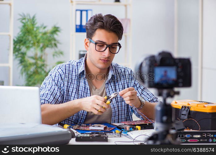 Vlogger recording computer repair on camera for vlog blog