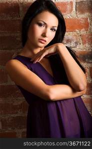 vlose up portrait of very cute asian girl with purple transparent dress near a bricks wall