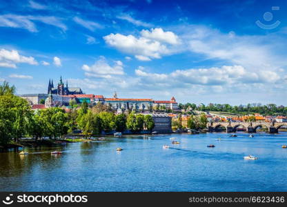 Vltava river and Gradchany Prague Castle and St. Vitus Cathedral and Charles bridge with people in paddle boats. Prague, Czech Republic. View of Vltava river and Gradchany, Prague