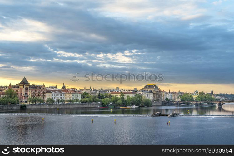 Vltava river and Prague City at sunrise. Amazing cityscape with the Vltava river and the beautiful buildings of Prague City, in the Czech Republic, at sunrise.