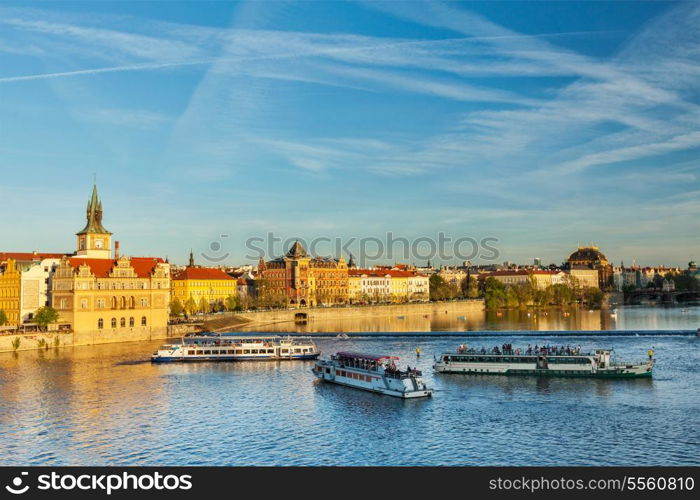 Vltava river with tourist boats and Prague Stare Mesto embankment view from Charles bridge on sunset. Prague, Czech Republic