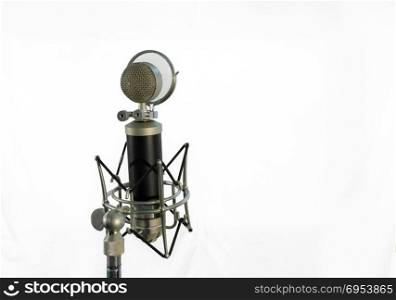 Vocal condenser microphone with wind screen isolated on white background.