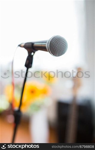 Vocal Microphone in focus against blurred audience at the conference or live concert