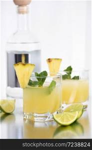Vodka cocktail with pineapple juice, a slice of lime, cooled with ice and mint