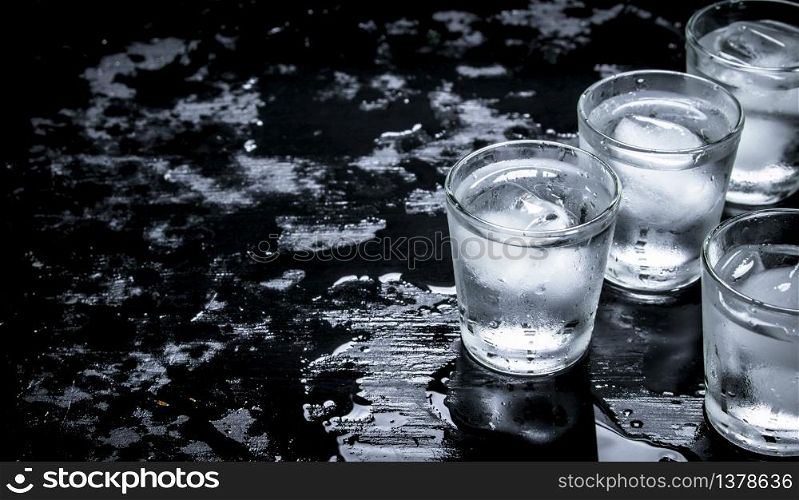 Vodka shots with ice. On the black chalkboard.. Vodka shots with ice.