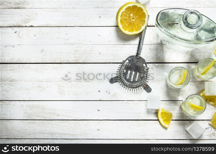 Vodka shots with lemon and ice. On a white wooden table.. Vodka shots with lemon and ice.