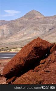 volcanic timanfaya red rock stone sky hill and summer in los volcanes lanzarote spain plant flower bush