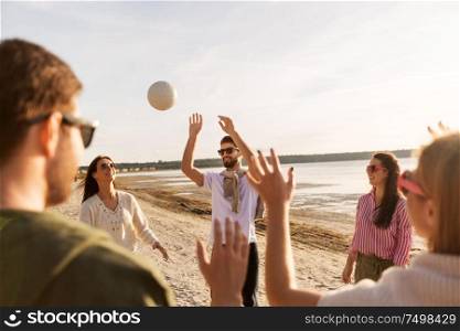 volleyball, leisure games and people concept - happy friends playing with ball on beach in summer. friends playing volleyball on beach in summer