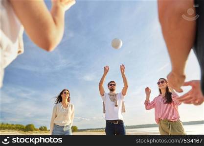 volleyball, leisure games and people concept - happy friends playing with ball on beach in summer. friends playing volleyball on beach in summer