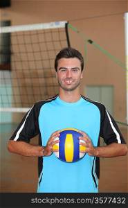 Volleyball player with ball in front of net