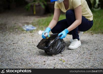 Volunteer charity woman hand holding garbage black bag and plastic bottle garbage for recycling for cleaning at park volunteering concept reuse and volunteer