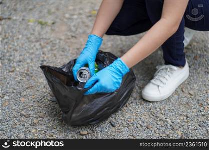 Volunteer charity womanhand holding garbage black bag and plastic bottle garbage for recycling for cleaning at park volunteering concept reuse and volunteer