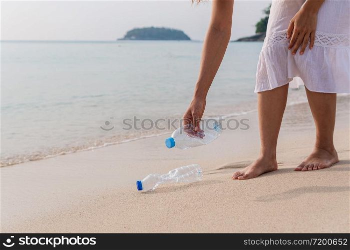 Volunteer woman collecting garbage on the beach. Ecology concept