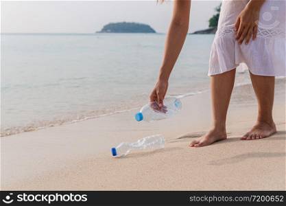 Volunteer woman collecting garbage on the beach. Ecology concept