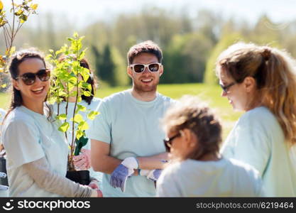 volunteering, charity, people and ecology concept - group of volunteers planting trees in park