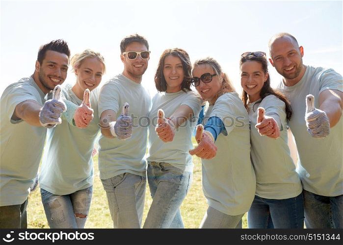 volunteering, charity, people, gesture and ecology concept - group of volunteers showing thumbs up outdoors. group of volunteers showing thumbs up outdoors