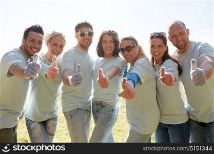 volunteering, charity, people, gesture and ecology concept - group of volunteers showing thumbs up outdoors. group of volunteers showing thumbs up outdoors