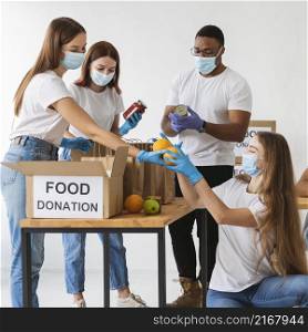 volunteers with medical masks preparing donation boxes