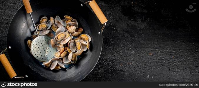 Vongole in a pot of water. On a black background. High quality photo. Vongole in a pot of water.