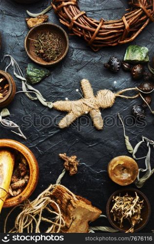 Voodoo doll, magical herbs and witchcraft attributes on an old table. Magic voodoo doll for ritual