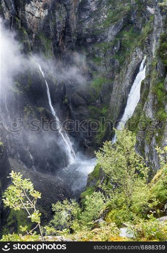 Voringfossen waterfall in norway seen from street level on sunny day