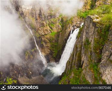 Voringsfossen waterfall, green summer mountains, Mabodalen canyon Norway. National tourist Hardangervidda route, touristroad Rv7, Eidfjord sightseeing tour.. Voringsfossen waterfall, Mabodalen canyon Norway