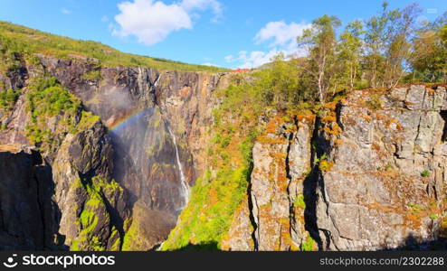 Voringsfossen waterfall with rainbow in summer, Mabodalen valley Norway. National tourist Hardangervidda route, touristroad 7, Eidfjord sightseeing tour.. Voringsfossen waterfall with rainbow, Norway