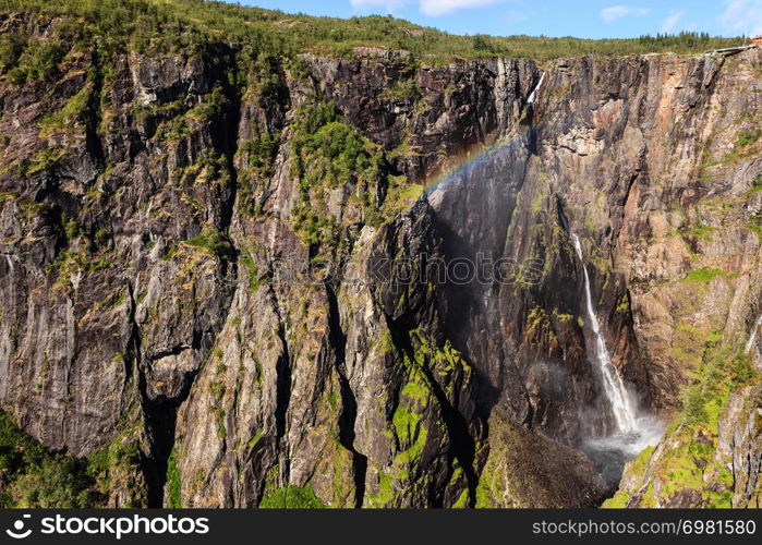 Voringsfossen waterfall with rainbow in summer, Mabodalen valley Norway. National tourist Hardangervidda route, touristroad 7, Eidfjord sightseeing tour.. Voringsfossen waterfall, Hardangervidda route, Norway