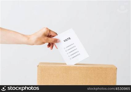 voting, civil rights and people concept - male hand putting vote into ballot box on election