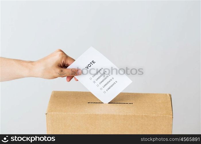 voting, civil rights and people concept - male hand putting vote into ballot box on election