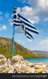 Vouliagmeni lake and greek flag  near Loutraki in a summer day, Greece
