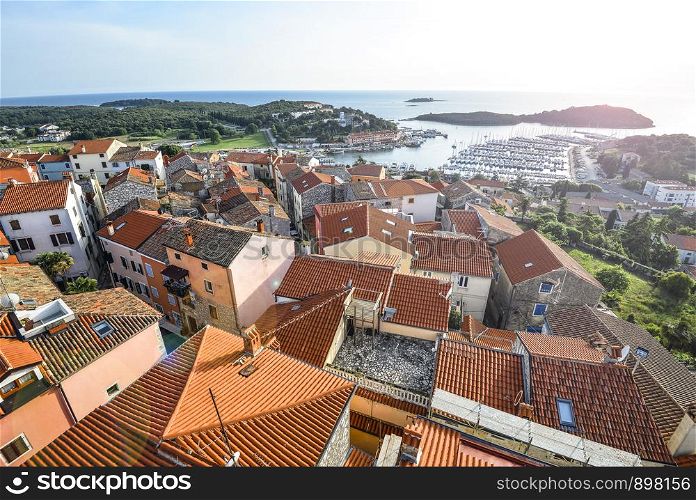 Vrsar, Croatia - May 20, 2018: View on old red roofs of small Croatian town Vrsar, yachts and the mediterranean sea, Croatia. View on old red roofs of small Croatian town Vrsar, Croatia