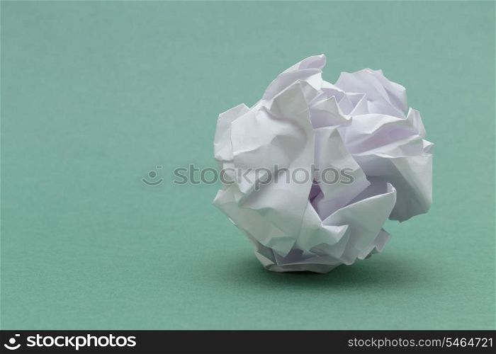 wad of crumpled paper on green background