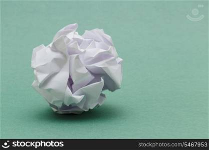 wad of crumpled paper on green background