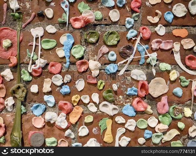 Wads of chewing gum cover a brick wall ias a gross landmark in Seattle near the Pike Place Market.