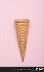 Wafer ice cream cone on pink pastel background flatlay