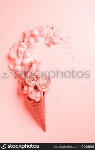 Waffle cone with composition of flowers and meringues in a color of the year 2019 Living Coral Pantone on a background same colors. Flat lay. Copy space.. Waffle cone with flowers and sweets on a color background of the year 2019 Living Coral Pantone. Top view. Place for text.