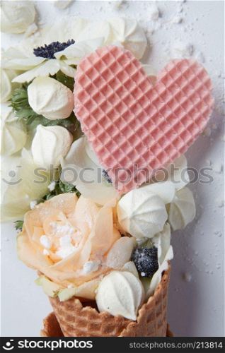 Waffle cone with organ flower and heart on a white background. Waffle cone with composition of flowers