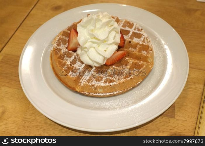 Waffle with whipped cream, strawberry and icing