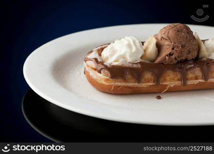 Waffles and ice cream in a dish on a dark background. Waffles and ice cream in a dish