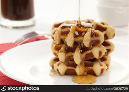 Waffles with honey on white plate
