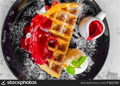 Waffles with strawberry and Vanilla Ice Cream on table