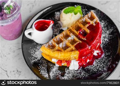 Waffles with strawberry and Vanilla Ice Cream on table