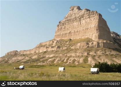 Wagons are situated at the base of Scott's Bluff in Nebraska