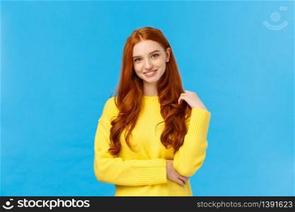 Waist-up shot attractive flirty redhead modern girl millennial in yellow sweater, playing with hair and smiling lovely with entertained, curious expression, looking camera having conversation.. Waist-up shot attractive flirty redhead modern girl millennial in yellow sweater, playing with hair and smiling lovely with entertained, curious expression, looking camera having conversation