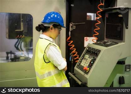 Waist up technician woman check monitor screen control of lathe milling robot machine in factory. Concept of inspection or audit process to get better industrial business