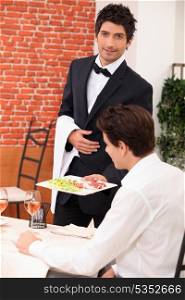 Waiter deliver in meal in restaurant
