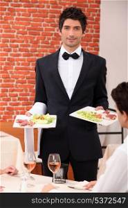 Waiter delivering meals to table